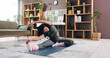 © peopleimages.com - Stretching, yoga and woman in home in morning for flexibility, calm or balance in living room. Pilates, zen and female person with exercise on mat in lounge for wellness, health or activity in house.