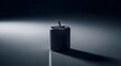 © StockShift - Single unlit dark gray pillar candle with wick on a reflective surface, dramatic lighting