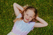 © Westend61 - Portrait of smiling young girl lying on grass outdoors