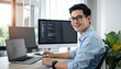 © photostockatinat - A smiling male programmer at his workstation, surrounded by technological equipment and coding interfaces. He wears glasses and a light blue shirt.