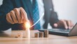 © photostockatinat - A person hand using graph increase on coins with the laptop computer