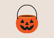 © ST.art - Orange pumpkin bucket with jack o lantern face, black handle, used for trick or treat candy collection on Halloween night. Flat vector illustration