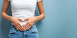 © dadakko - Young woman making a heart shape with hands on her stomach, health, menstrual pain, constipation and lifestyle concept