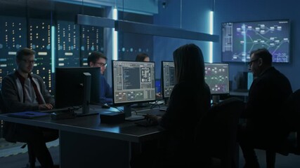 IT Specialists Concentrate on Analyzing Information on their Screens at Their Desks, Working With Multiple Monitors Displaying Technical Data, Code, Visualizations, Operations and System Monitoring 