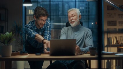 Mature Man and Young Colleague Discuss Software Development at a Computer in a Modern Office. They Focus on Digital Solutions and Technology Integration, Enhancing Project Collaboration and Innovation