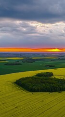 Wall Mural - Drone pullback hyperlapse of golden sunset above rich green farms and glowing orange sky