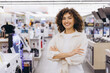 © anatoliycherkas - Saleswoman smiling with crossed arms in electronics store