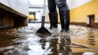 © Mach-1-Art - Person cleaning up floodwater with rubber boots.