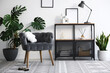 © New Africa - Stylish grey armchair, shelving unit and houseplants indoors. Interior design