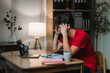 © PaeGAG - Young man struggling with a headache while working late on a laptop at home, feeling overwhelmed by stress and fatigue
