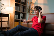 © PaeGAG - Teenage male lounging on sofa, wearing wireless headphones, enjoying music through smartphone, looking carefree