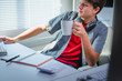 © PaeGAG - Teenager programmer sipping coffee while working diligently at a computer desk in a bright, modern office environment