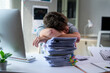 © PaeGAG - Stressed businessman sleeping on a pile of documents at the office, overwhelmed by fatigue and the pressures of an excessive workload