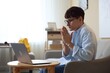 © New Africa - Worried student with clasped hands praying for good exam result at table indoors