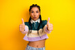 © deagreez - Young woman with braids on yellow background showing double thumbs up gesture in a casual trendy outfit