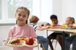 © New Africa - Little girl with tray of tasty food in school canteen