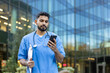 © Liubomir - Healthcare worker checking phone while outside a modern building