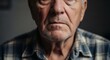 © Ace13 - Close-up portrait of an elderly man with weathered skin and a pensive expression, wearing a plaid shirt.