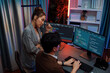 © InfiniteFlow - IT developers discussing with point to intelligent website development coder system running data online on pc of two screens with information technology at neon light room at modern office. Infobahn.