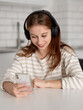 © tan4ikk - Happy Teen Girl Using Smartphone With Headphones