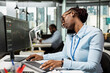 © DC Studio - Investment consultant discusses market trends over phone call with clients in office. African american woman making trading decisions while talking on smartphone at PC desk