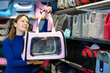 © JackF - Young interested woman choosing comfortable dog carrier for transportation small four-legged friend in pet shop