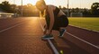 © Rumput - Woman tying shoe lace on running track