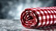 © calista - Rolled red and white checkered tablecloth on a stone surface