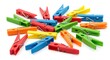 © Erisna Yolanda - Scattered colorful plastic clothespins lay haphazardly on a white surface, creating a vibrant and playful arrangement