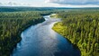 © Samady - An aerial photograph showcases a wide, winding river flowing through a dense, evergreen forest. The riverâ€™s surface reflects the sky, appearing dark and deep.