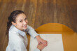 © wavebreak3 - Woman wearing white blouse sitting at wooden desk smiling at camera with open notebook, copy space