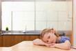 © WavebreakMediaMicro - School-age girl leaning on table in kitchen near stainless steel sink and plant, copy space