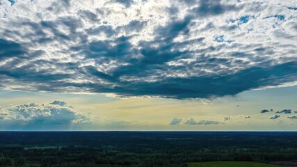 Wall Mural - Dark rain clouds casting shadows over vast rural landscape and farms in drone hyperlapse