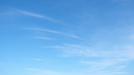 Wall Mural - a time lapse of this blue sky shows faint wisps of cirrus clouds stretching across a vast expanse, r