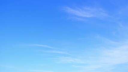 Wall Mural - A timelapse of blue sky highlights delicate wisps of cirrus clouds drifting gently, representing stable weather, calm winds, and clear atmospheric conditions, often linked with fair and pleasant days.