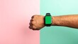 © Dini Wahyuni - Close up of a man's wrist with a modern smartwatch featuring a blank green screen, perfect for mockups, on a stylish split-color background.