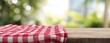 © Maxi - The Red and White Checkered Tablecloth on a Wooden Outdoor Table