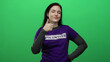© Krakenimages.com - Woman smiling wearing purple volunteer shirt gives thumbs up against green background showcasing enthusiasm and commitment.