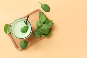 Wall Mural - Glass of fresh spinach smoothie on yellow background