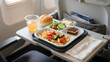 © abu - Airline meal on tray table in passenger airplane