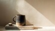 © Gilang - Ceramic mug and small stone on textured surface, dappled in natural light
