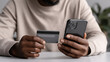 © buraratn - Online shopping has become common activity, as seen in this of person holding smartphone and credit card, ready to make purchase. scene captures essence of modern consumerism and convenience