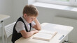 © Olia - Child with reading disorder concentrating on homework with frustrated expression, concept of dyslexia and literacy problems in early learning