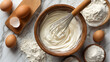 © Anthichada - A whisk folding egg into cake batter in a glass mixing bowl preparing for baking, Surrounded by flour and eggs on the table at kitchen room