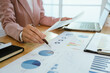 © Witoon - A professional business environment with charts and graphs on a laptop, symbolizing financial analysis, corporate strategy, economic planning, data review, management reporting, growth, consulting, ac