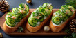 Three elegant cucumber canapés on wooden board. Topped with cheese and herbs. Surrounded by Christmas decorations like pine cones and ornaments.