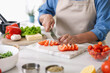© New Africa - Senior woman cooking at white marble table in kitchen, closeup