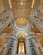 Ornate, gilded dome and ceiling of St. Peter's Basilica, features a golden sunburst design, decorated with intricate mosaics and paintings. Luxurious decoration of the Vatican iconic interior