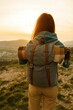 © Kirill - Traveler with backpack standing on mountain enjoying sunrise and scenic view adventure lifestyle