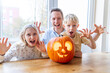 © ADDICTIVE STOCK - Family enjoying Halloween pumpkin carving fun together